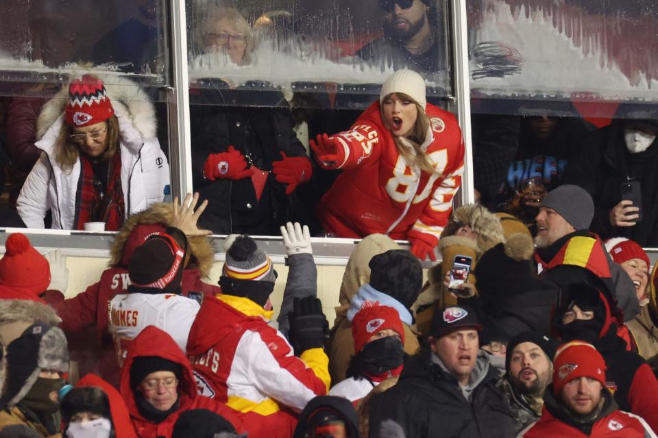 Wild Card Weekend: Taylor Swift celebrates with fans during the game between the Miami Dolphins and the Kansas City Chiefs at Arrowhead Stadium.