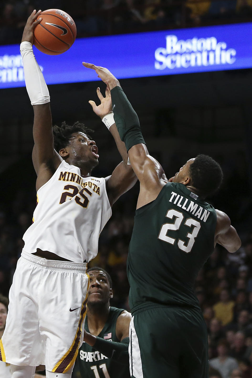 Minnesota's Daniel Oturu, left, shoots over Michigan State's Xavier Tillman during an NCAA college basketball game Sunday, Jan. 26, 2020, in Minneapolis. (AP Photo/Stacy Bengs)