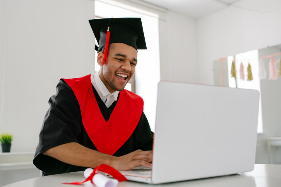 A graduate uses a laptop.