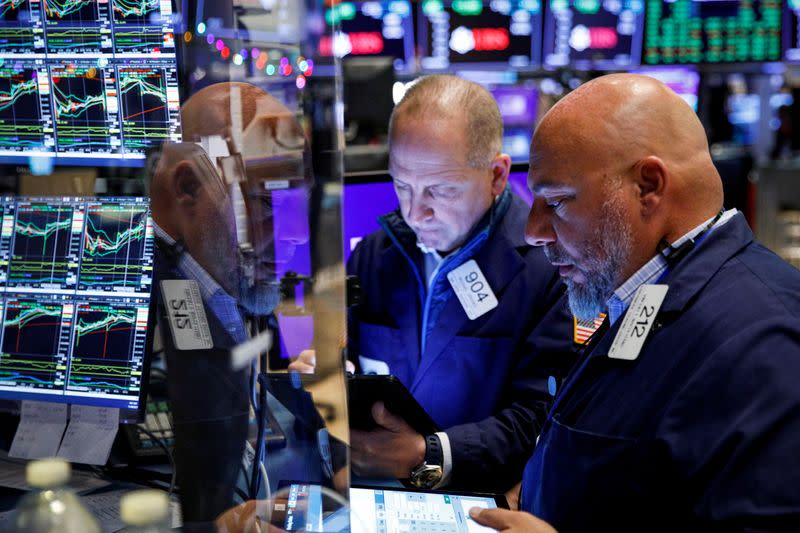 FILE PHOTO: Traders work on the floor of the NYSE in New York