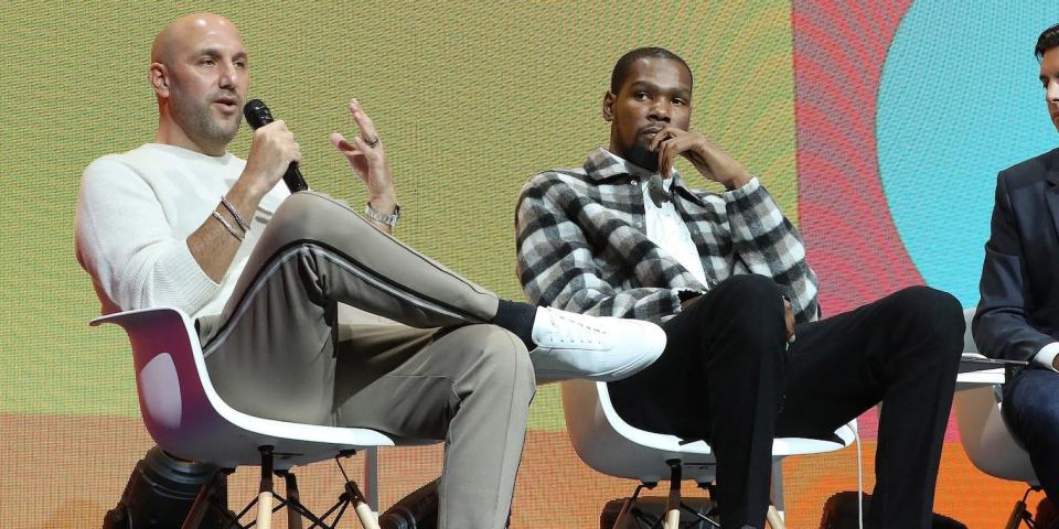 Rich Kleiman and Kevin Durant sit on stage and speak during a summit in 2019.