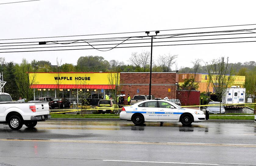 Law enforcement investigate the scene outside a Waffle House where four people were killed