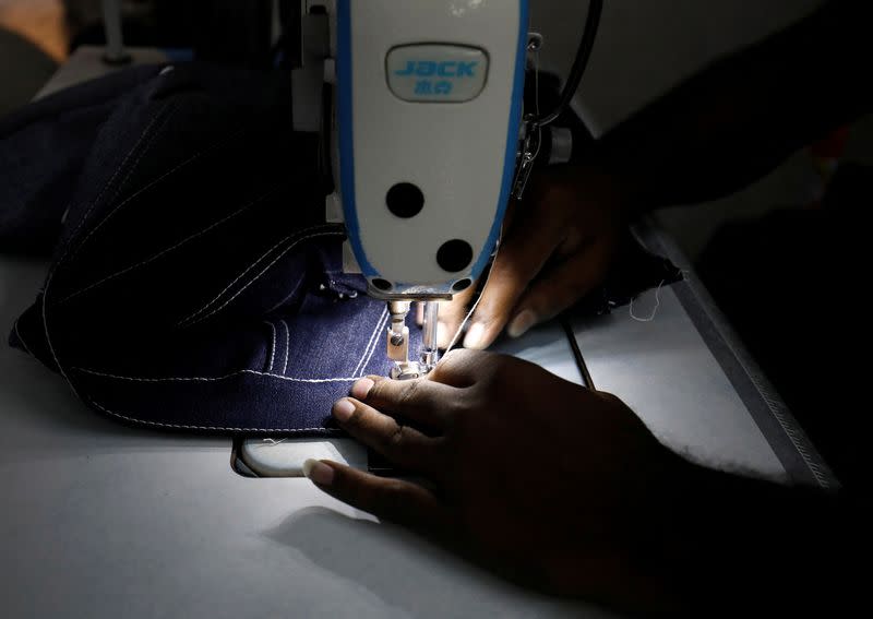A worker sews jeans in a garments manufacturing unit in Ahmedabad