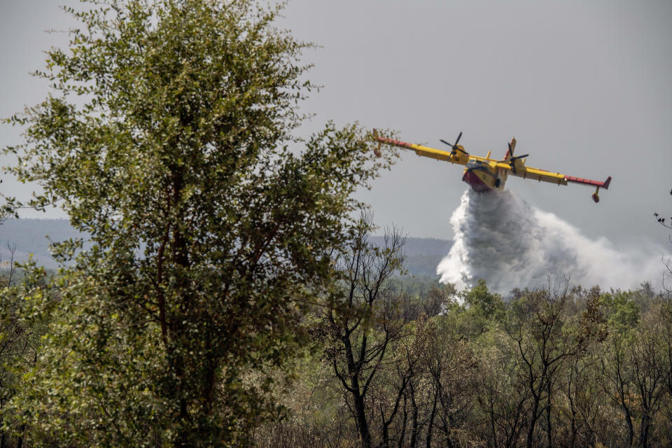 Fire fighting planes drop water to put out a forest blaze in Laarache, northern Morocco, Friday, July 15, 2022. Fires fanned by strong winds and extreme temperatures have spread across hundred of hectares in North Africa since Thursday evening. (AP Photo)