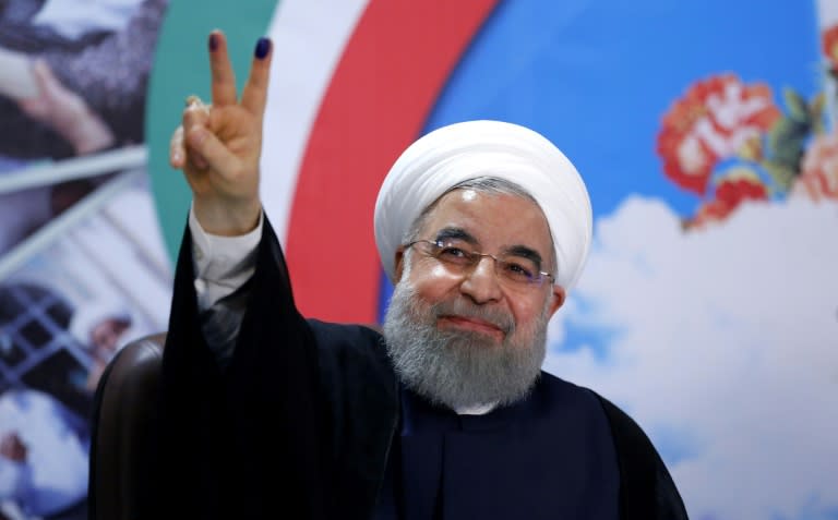 Iranian President Hassan Rouhani gestures to the camera after registering to run for re-election in Tehran on April 14, 2017