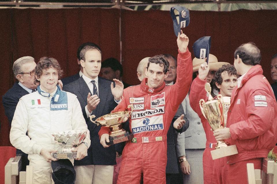 FILE - In this May 7, 1989 file photo, Prince Albert of Monaco, left, applauds Brazil’s Ayrton Senna, center, winner of the Monaco formula One grand prix ahead of Prost, right, on the podium in Monaco. Despite his career being cut short when he was 34, his 41 wins stand third all-time behind Michael Schumacher's 91 and rival Alain Prost's 51. He died at the 1994 San Marino Grand Prix. (AP Photo/Gilbert Tourte, File)