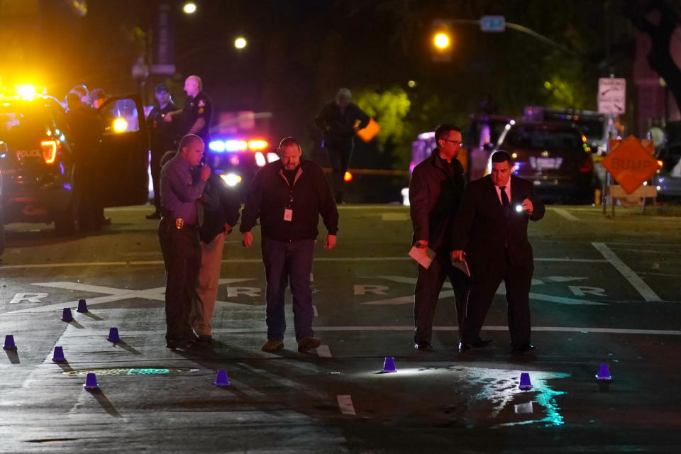 Authorities search area of the scene of a mass shooting with multiple deaths in Sacramento, Calif. Sunday, April 3, 2022. (AP Photo/Rich Pedroncelli)