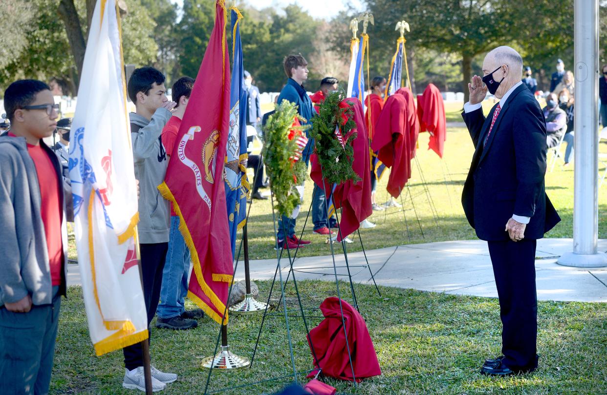 Dr. David Goetsch, right, salutes a wreath during a Wreaths Across America ceremony at Beal Memorial Cemetery. Goetsch, a Marine Corps veteran, is one of nine Okaloosa County veterans being honored this month for his induction into the Florida Veterans' Hall of Fame.