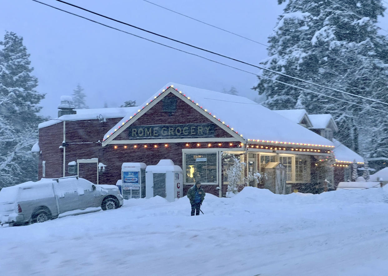 A person shovels snow outside a grocery store northeast of Bellingham, Wash.