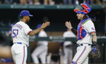 Texas Rangers relief pitcher Joely Rodriguez (57) and catcher Jonah Heim celebrate a 5-3 win over the Oakland Athletics after a baseball game, Wednesday, June 23, 2021, in Arlington, Texas. (AP Photo/Brandon Wade)