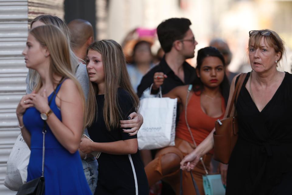 People react as they leave a cordoned-off area.