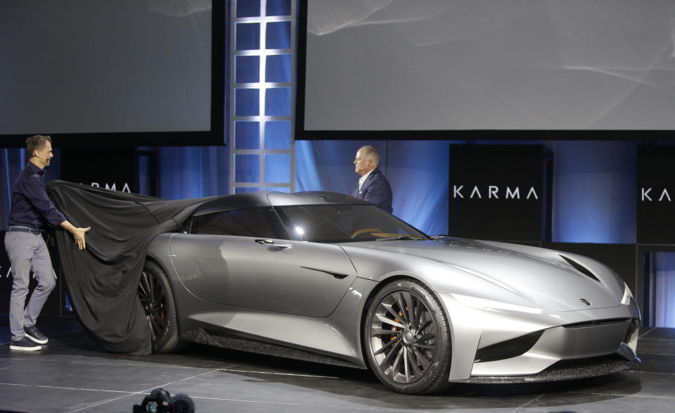 CORRECTS VEHICLE TO KARMA SC2 CONCEPT INSTEAD OF KARMAN VISION SC2 - Karma Automotive Andreas Thurner, Vice President for Global Design and Architecture, left, and Todd George, VP of Platform Engineering at Karma Automotive, unveil the Karma SC2 concept vehicle at the Automobility LA Auto Show in Los Angeles Tuesday, Nov. 19, 2019. (AP Photo/Damian Dovarganes)