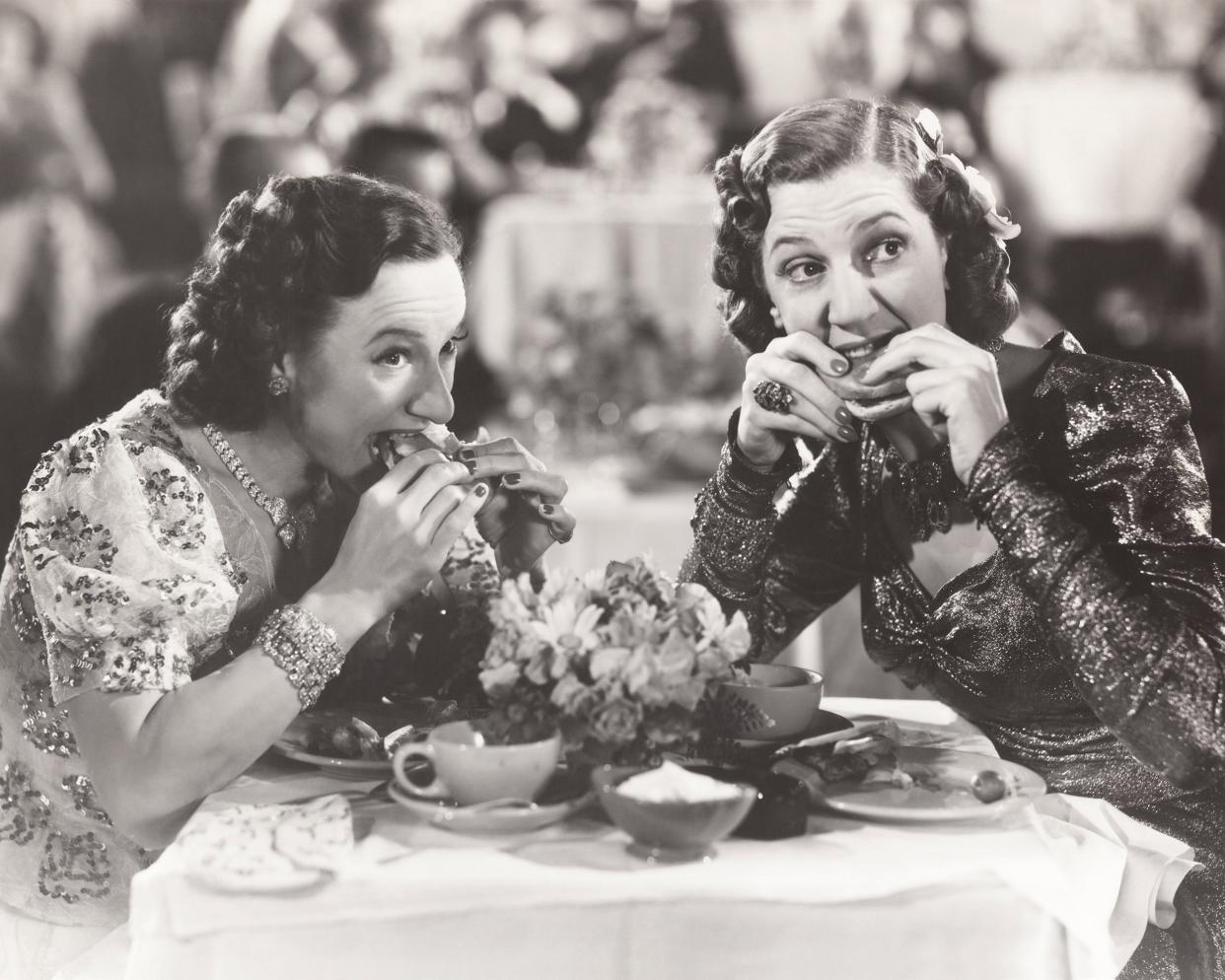 two women distracted from their meal during the 1940s