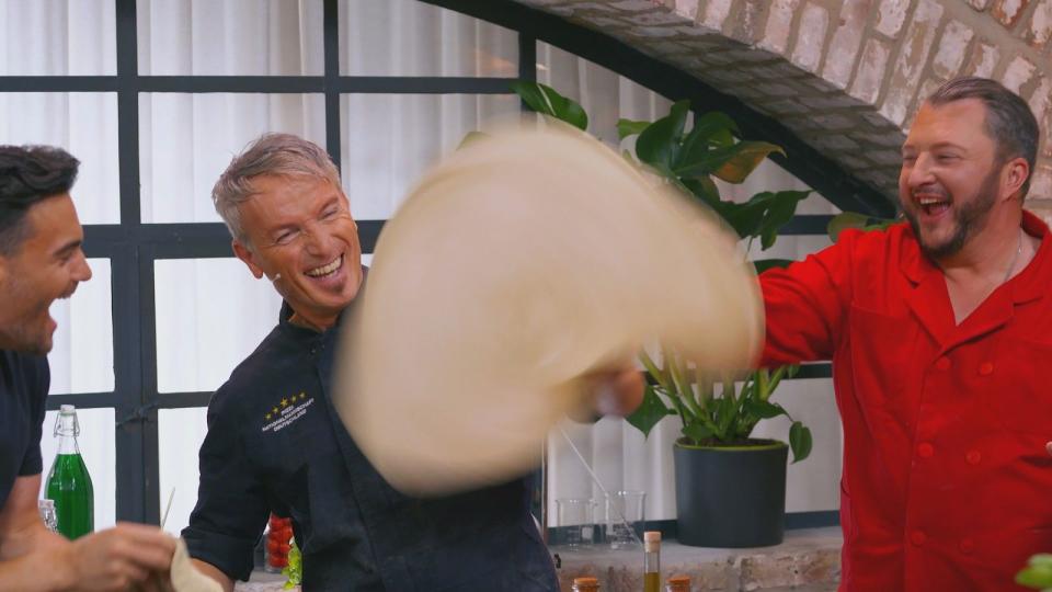 Pizza-Lehrer Umberto (Mitte) hat den richtigen Dreh raus: Er lässt im "Lege-Lab" die Teigfladen tanzen. (Bild: RTL)