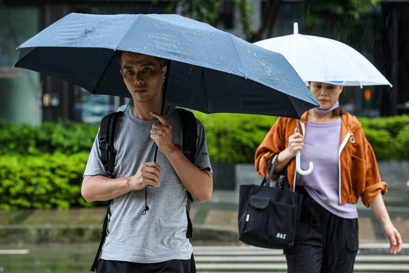 新北午後陣雨  民眾撐傘過馬路 中央氣象署23日下午針對雙北地區發布大雷雨即時訊 息，慎防劇烈降雨、雷擊。圖為新北市新店區午後下 雨，民眾撐傘過馬路。 中央社記者鄭清元攝  113年6月23日 