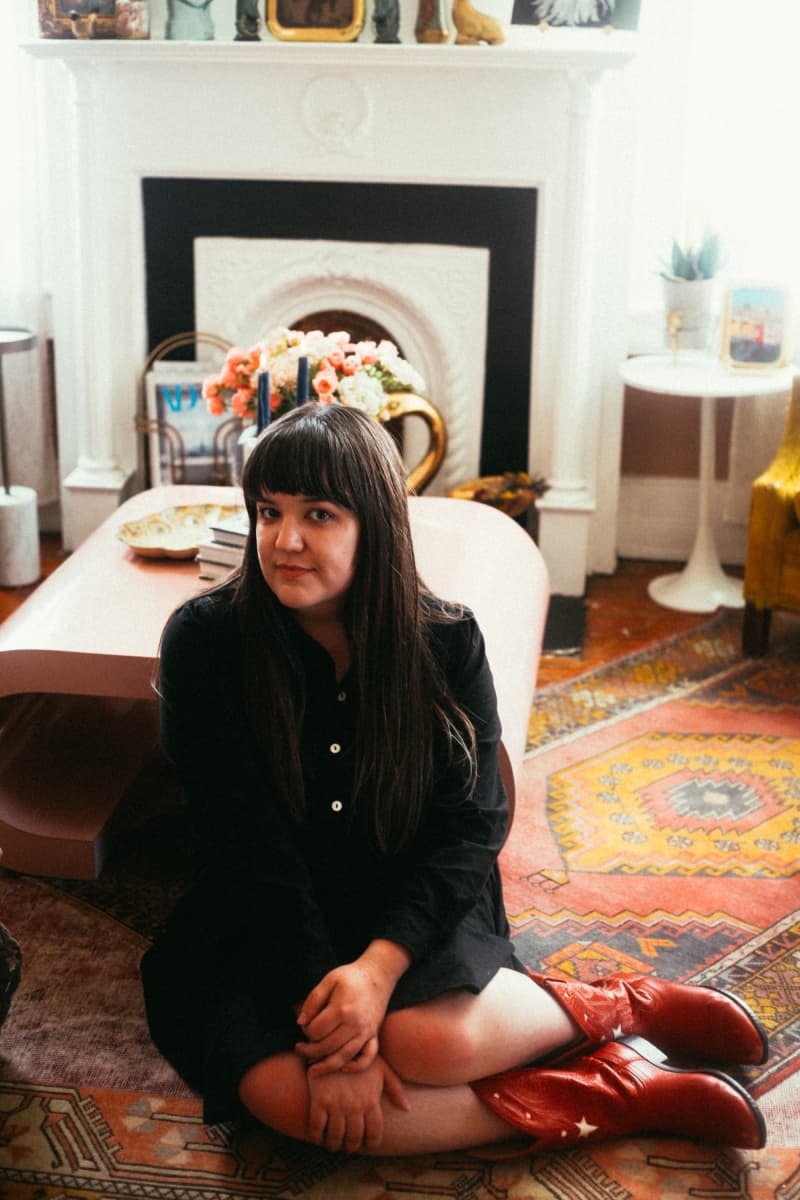 Dweller sits on living room floor with patterned area rugs.