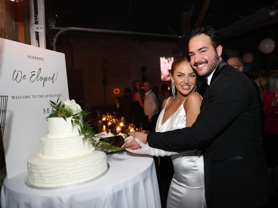 A bride and groom cutting a cake.