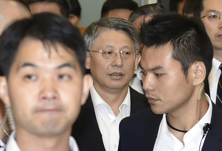 Sha Hailin (C), Shanghai Municipal Committee United Front Work Department Director, is surrounded by security guards as he arrives at Songshan airport near Taipei, on August 22, 2016
