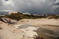 A man takes a picture on the dunes of the closed Crescent Beach before Hurricane Dorian in St. Augustine