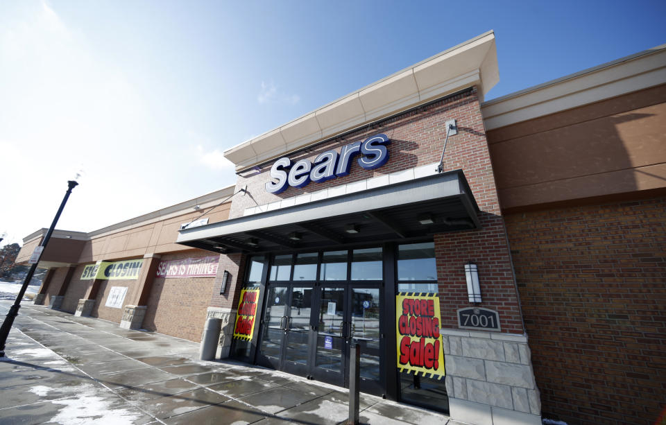 FILE- In this Jan. 1, 2019, file photo signs mark the closing of a Sears store in the Streets of Southglenn mall in Littleton, Colo. Sears confirmed Thursday, Jan. 17, that chairman and largest shareholder Eddie Lampert’s hedge fund has won tentative approval for a $5.2 billion plan to buy 425 stores and the rest of its assets. (AP Photo/David Zalubowski, File)