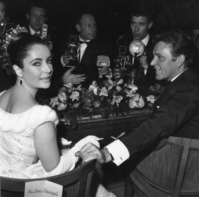 Welsh screen and stage actor Richard Burton and screen actress Elizabeth Taylor with photographers at a screening of David Lean's Lawrence of Arabia. 