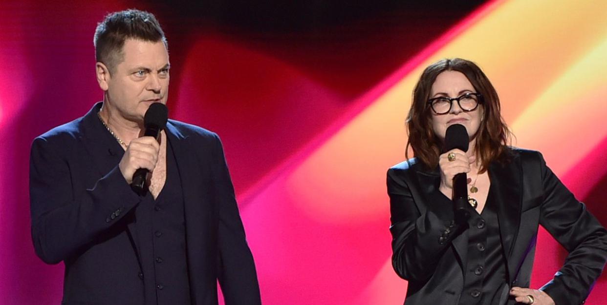 nick offerman, megan mullally presenting on stage, both wearing dark suits