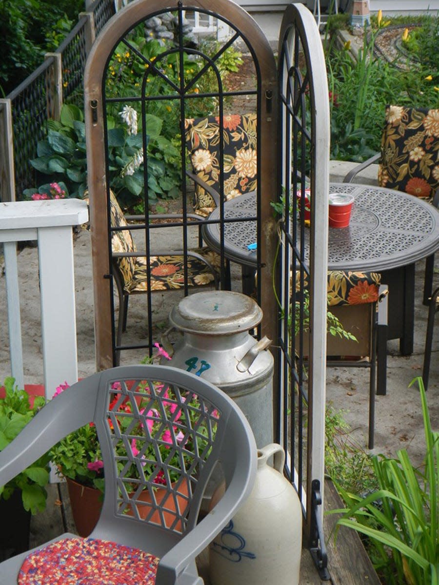 A simple arched cathedral-style window on the author's deck serves as a reverent frame for the garden beyond it — one way to establish a memorial to a loved one.