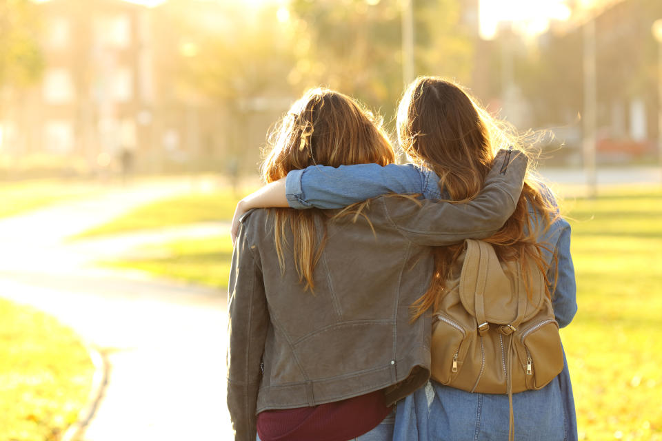 Affectionate friends walking at sunset in a park