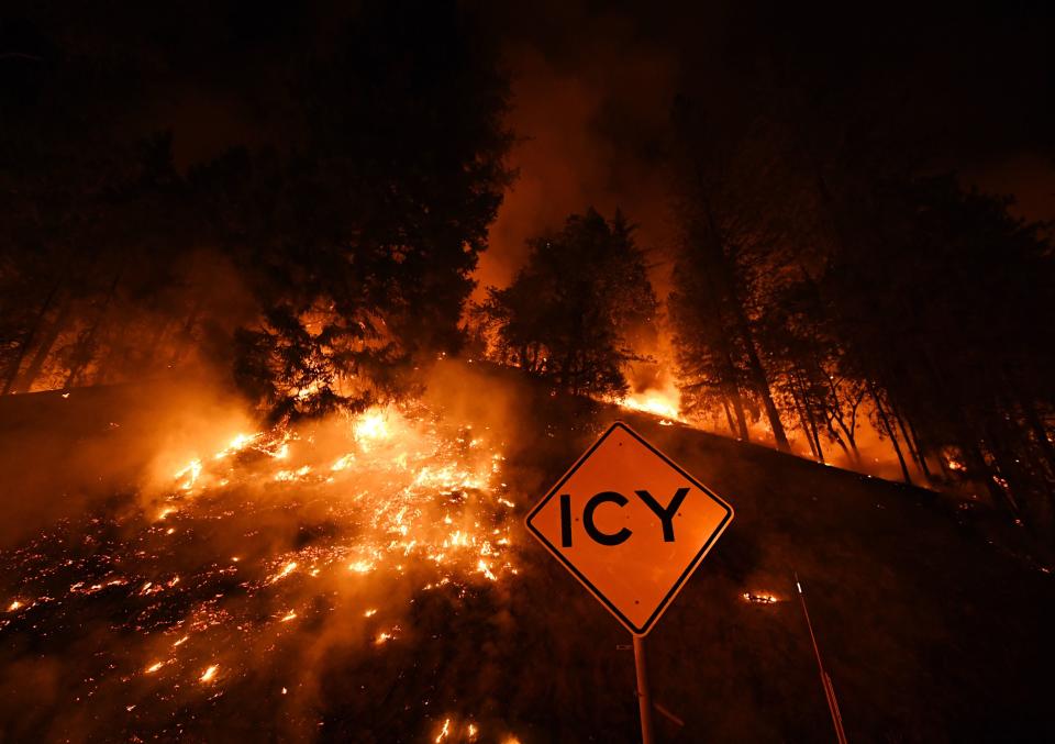 A road sign warns for ice as the Carr Fire continues to spread toward the towns of Douglas City and Lewiston near Redding, California.