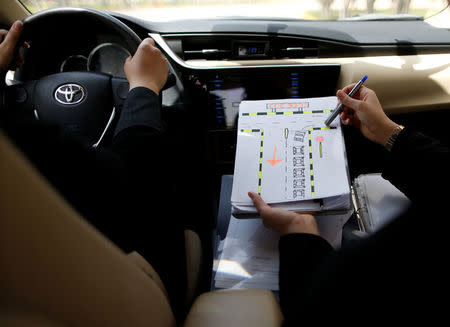 A driving instructor teaches road signs to trainee Amira Abdulgader during a driving lesson at Saudi Aramco Driving Center in Dhahran, Saudi Arabia, June 6, 2018. REUTERS/Ahmed Jadallah