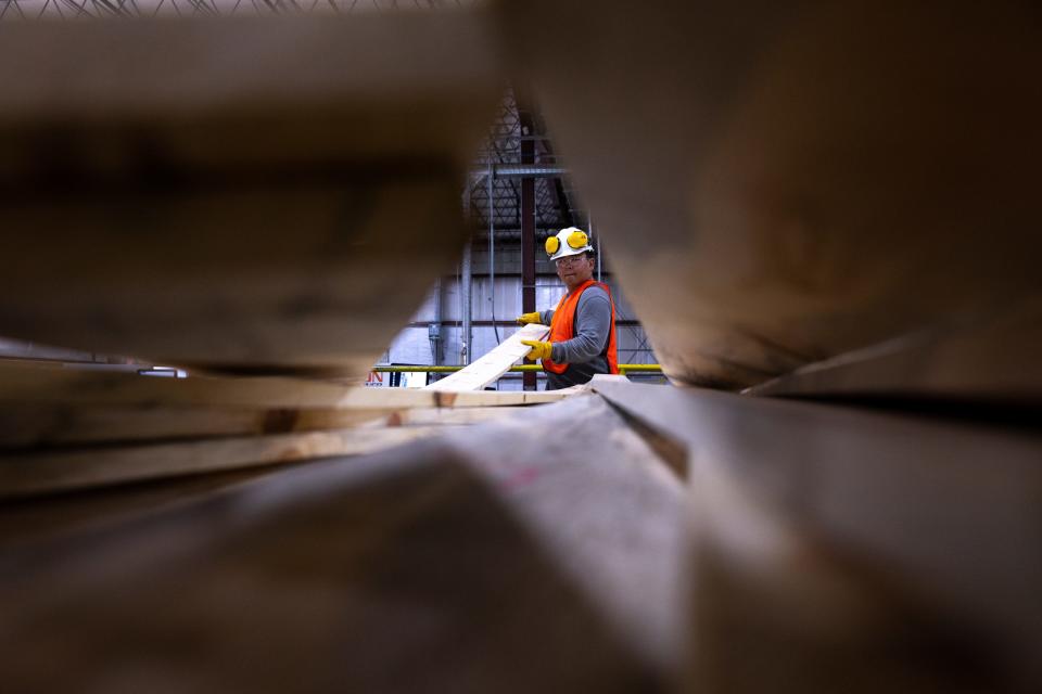 Billy Betoney III sorts ponderosa pine boards, October 5, 2021, on the NewLife Forest Restoration engineered wood product line, located at 14005 E Old Highway 66, Bellemont, Arizona.