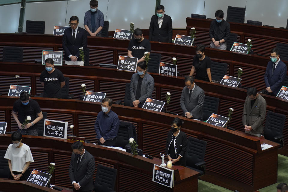 Pan-democratic legislators observe one minute of silence for the 31st anniversary of Tiananmen crackdown before a Legislative Council meeting to debate national anthem bill in Hong Kong, Thursday, June 4, 2020. On the anniversary of Tiananmen crackdown, Hong Kong continued debating a contentious law that makes it illegal to insult or abuse the Chinese national anthem. (AP Photo/Vincent Yu)