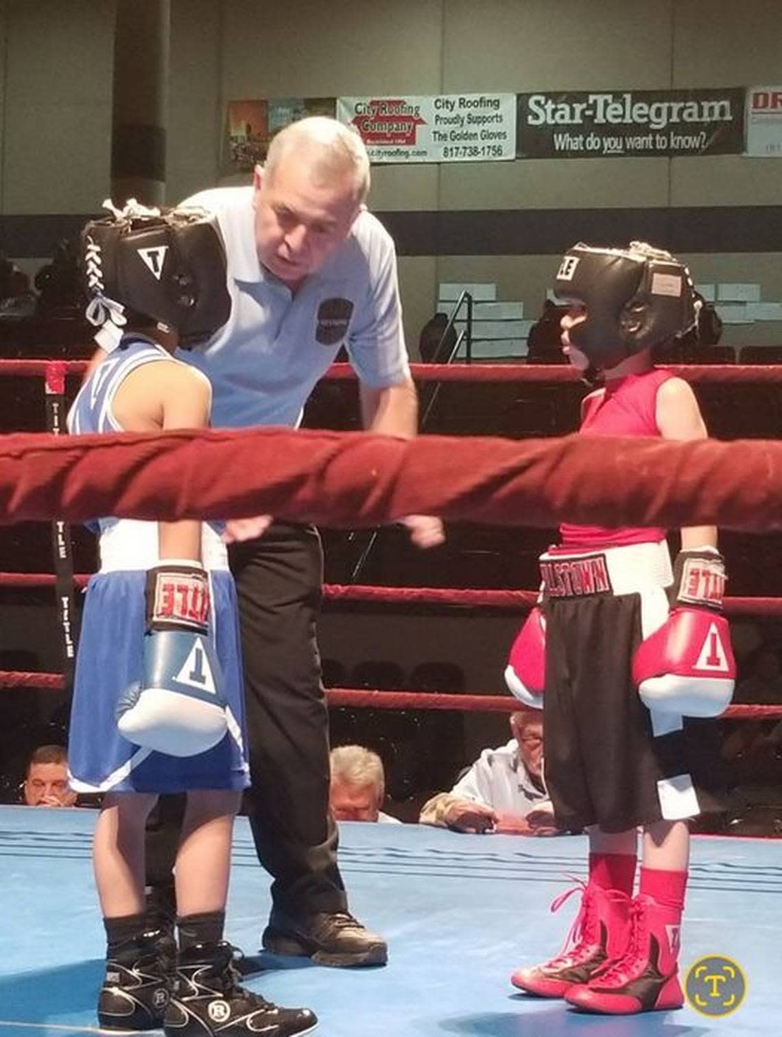 Joe Ponce referees a match between two young fighters at a the Regional Golden Gloves in Fort Worth.