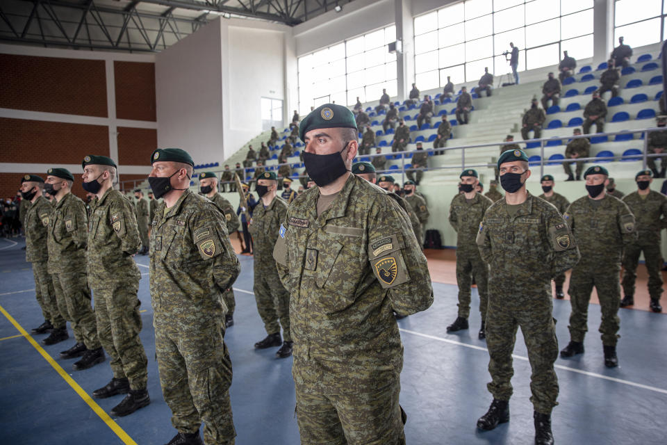 Kosovo Security Force (KSF) members wearing protective face masks line up during a peacekeeping mission deployment ceremony held at the army barracks in Pristina, Tuesday, March 9, 2021. Kosovo is sending a military platoon to Kuwait, its first ever involvement in an international peacekeeping mission. A ceremony was held Tuesday at the army barracks in the capital, Pristina, with the presence of top country leaders and western military attaches. Kosovo is sending the military unit following a request from the U.S. Central Command. (AP Photo/Visar Kryeziu)