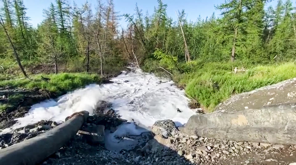 In this handout frame taken from video released Sunday June 28, 2020, by Novaya Gazeta, showing what the report is water from a Norilsk Nickel enrichment plant gushing out of a pipe and into a river which also runs into the lake near Norilsk, 2,900 kilometers (1,800 miles) northeast of Moscow, Russia. Russia's main criminal investigation body has launched a probe after a report that a nickel-processing plant was pumping water contaminated with heavy metals into the Arctic tundra. (Elena Kostyuchenko, Novaya Gazeta via AP)