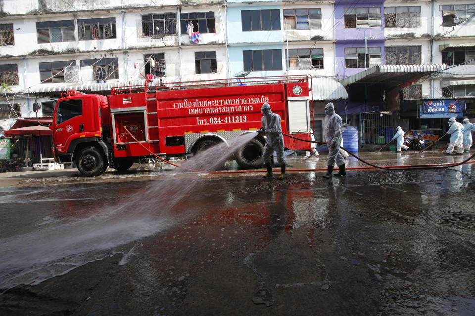 Workers spray disinfectant as a precaution against the coronavirus at shrimp market in Samut Sakhon, Thailand, Monday, Jan. 25, 2021. Thailand on Monday registered a new daily high of 914 confirmed new cases of the coronavirus at the province near the capital Bangkok, where a major outbreak occurred in December. (AP Photo)