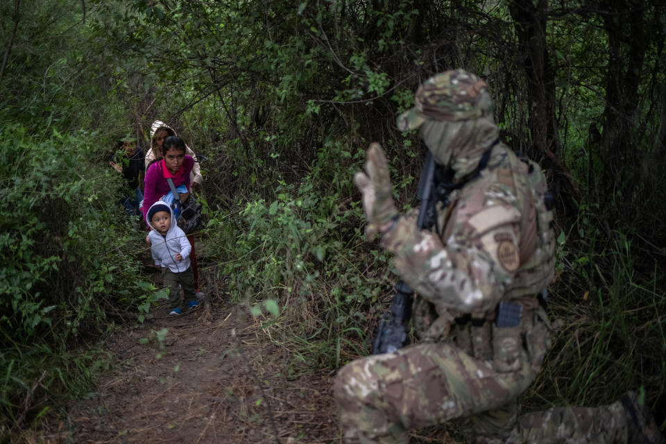 A member of the U.S. Border Patrol Tactical Unit waves to a family that illegally crossed the Rio Grande river to enter the U.S. from Mexico in Fronton, Texas, on Oct. 18, 2018. (Photo: Adrees Latif/Reuters)