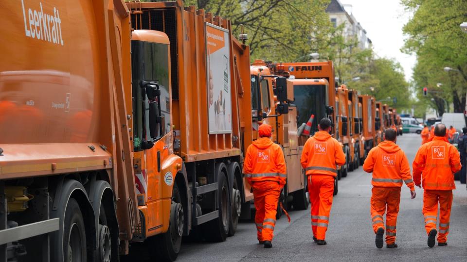 Mitarbeiter der Berliner Stadtreinigung gehen an abgestellten BSR-Fahrzeugen vorbei. In Potsdam werden die Tarifverhandlungen für den Öffentlichen Dienst Mitte September fortgesetzt.