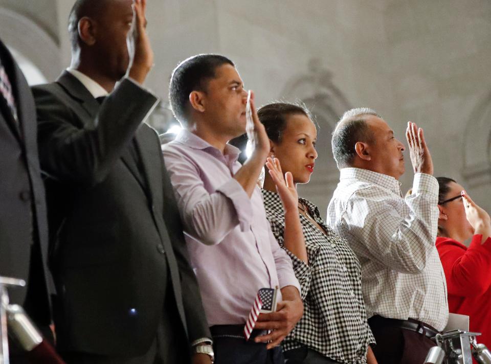 People take the Oath of Allegiance at a naturalization ceremony at the National Archives in Washington on July 4, 2019.