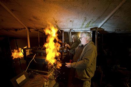 Michael Holmes, who lives on a fixed income and crafts knifes as a hobby, uses a forge in his workshop in Fort Bragg, California February 25, 2014. REUTERS/Noah Berger