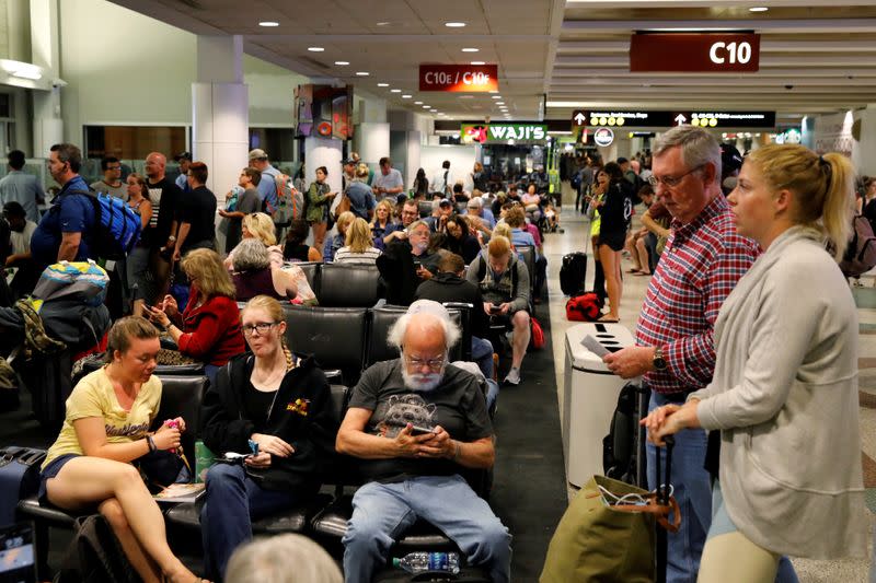 FILE PHOTO: Air Alaska passengers wait in the terminal following an incident where an airline employee took off in an airplane, at Seattle-Tacoma International Airport in Seattle, Washington