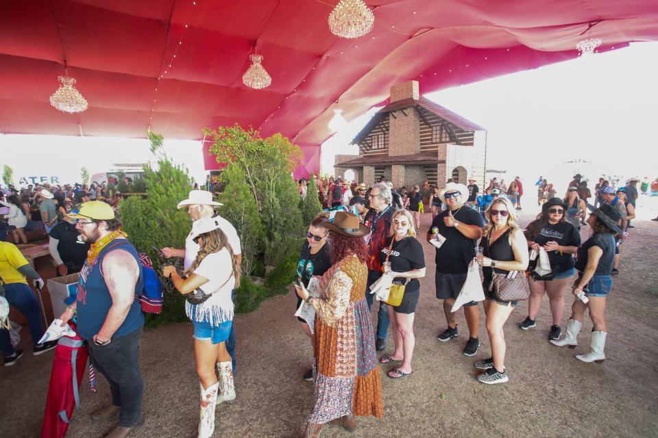 Festivalgoers wait in line to sew a bandanna at the Yellowstone Dutton Ranch during Stagecoach in Indio, Calif., on Friday, April 26, 2024.