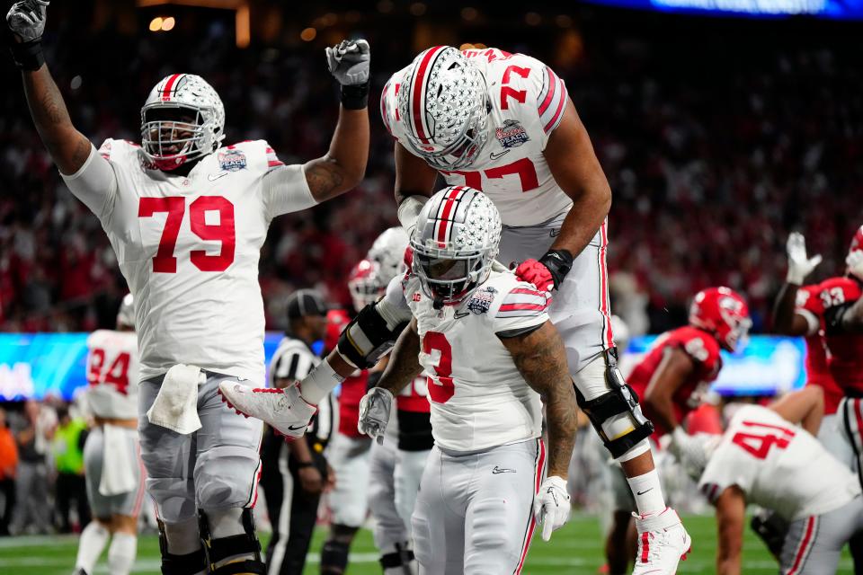 Dec 31, 2022; Atlanta, Georgia, USA; Ohio State Buckeyes running back Miyan Williams (3) celebrates a rushing touchdown with offensive lineman Paris Johnson Jr. (77) against Georgia Bulldogs during the second quarter of the Peach Bowl in the College Football Playoff semifinal at Mercedes-Benz Stadium. 