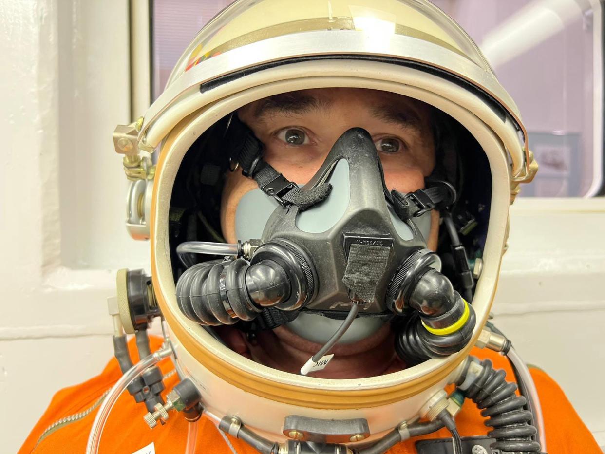 Miguel Iturmendi with the visor of the helmet of his partial pressure suit raised, as he sat in the altitude chamber at the John D. Odegard School of Aerospace Sciences at the University of North Dakota. He will wear the suit when he attempts to pilot Helios Horizon, an electric-powered airplane, into the stratosphere.