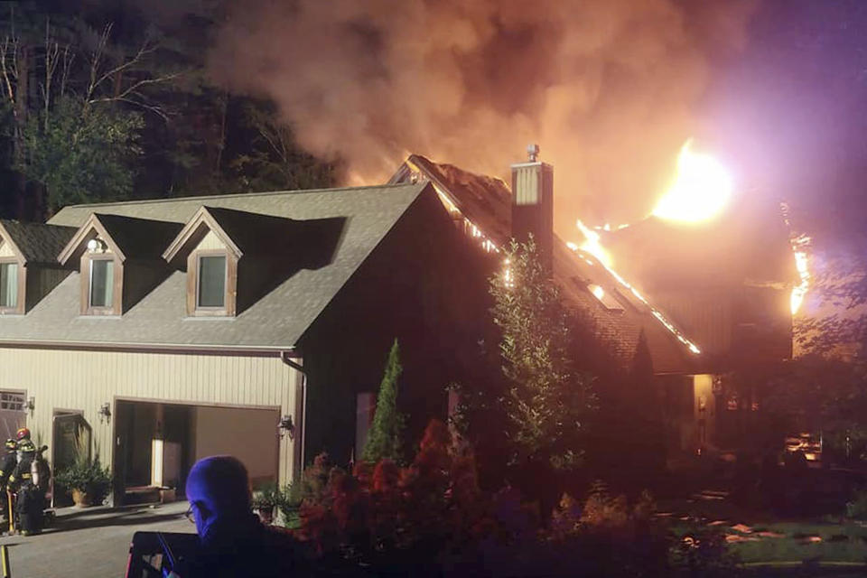 In this Sunday, Aug. 9, 2020 photo, a massive fire engulfs the home of cooking show star Rachael Ray, in Lake Luzerne, NY. Ray's representative said in a statement that Ray, her husband and dog were safe, but that the extent of damage to the home was not yet clear. (Courtesy Kenneth Dickinson via AP)