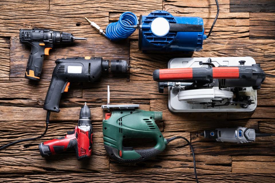 Various Power Tools Laying On Wooden Desk