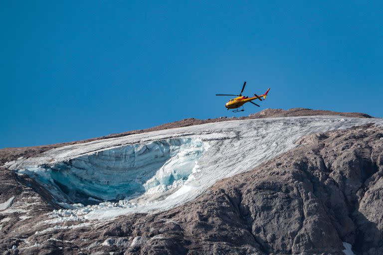 Un helicóptero de rescate sobrevuela el 4 de julio de 2022 el glaciar que se derrumbó la víspera en la montaña de Marmolada, la más alta de los Dolomitas.
