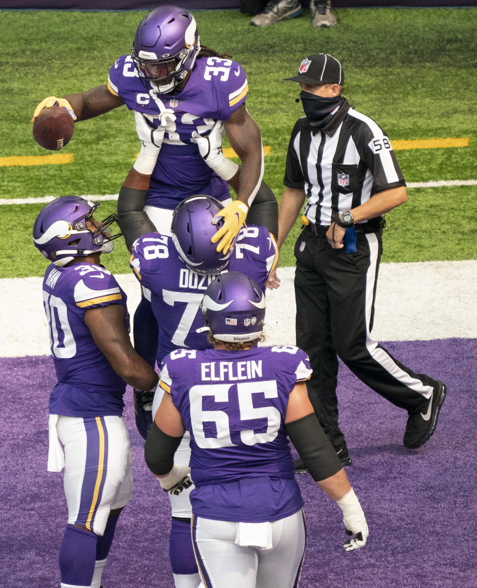 Minnesota Vikings running back Dalvin Cook (33) celebrates his first quarter touchdown run as teammate Dakota Dozier (78) lifts him up, during an NFL football game against the Green Bay Packers Sunday, Sept. 13, 2020, in Minneapolis. (Jerry Holt/Star Tribune via AP)