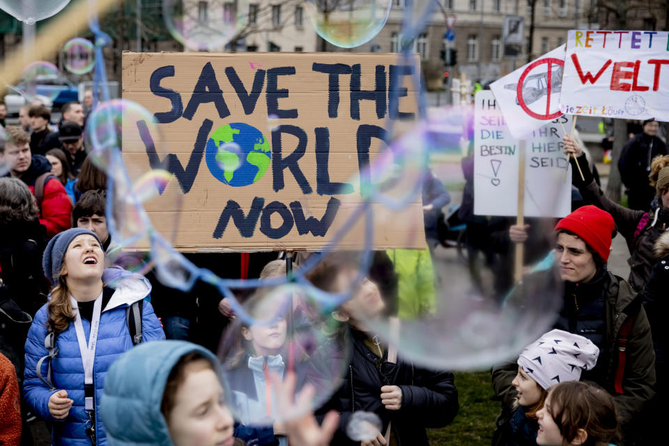 Young people protest for climate action with a sign reading 'Save the World Now" during a 'Friday for Future' demonstration in Berlin, Germany, Friday, March 22, 2019. (Christoph Soeder/dpa via AP)