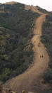 <p>Firemen clear a fire break and lay ten thousand feet of hose across a canyon from atop Camino Cielo down to Gibraltar to make a stand should the fire move in that direction Wednesday Dec. 13, 2017, in the Santa Ynez Mountains area of Santa Barbara, Calif. (Photo: Mike Eliason/Santa Barbara County Fire Department via AP) </p>